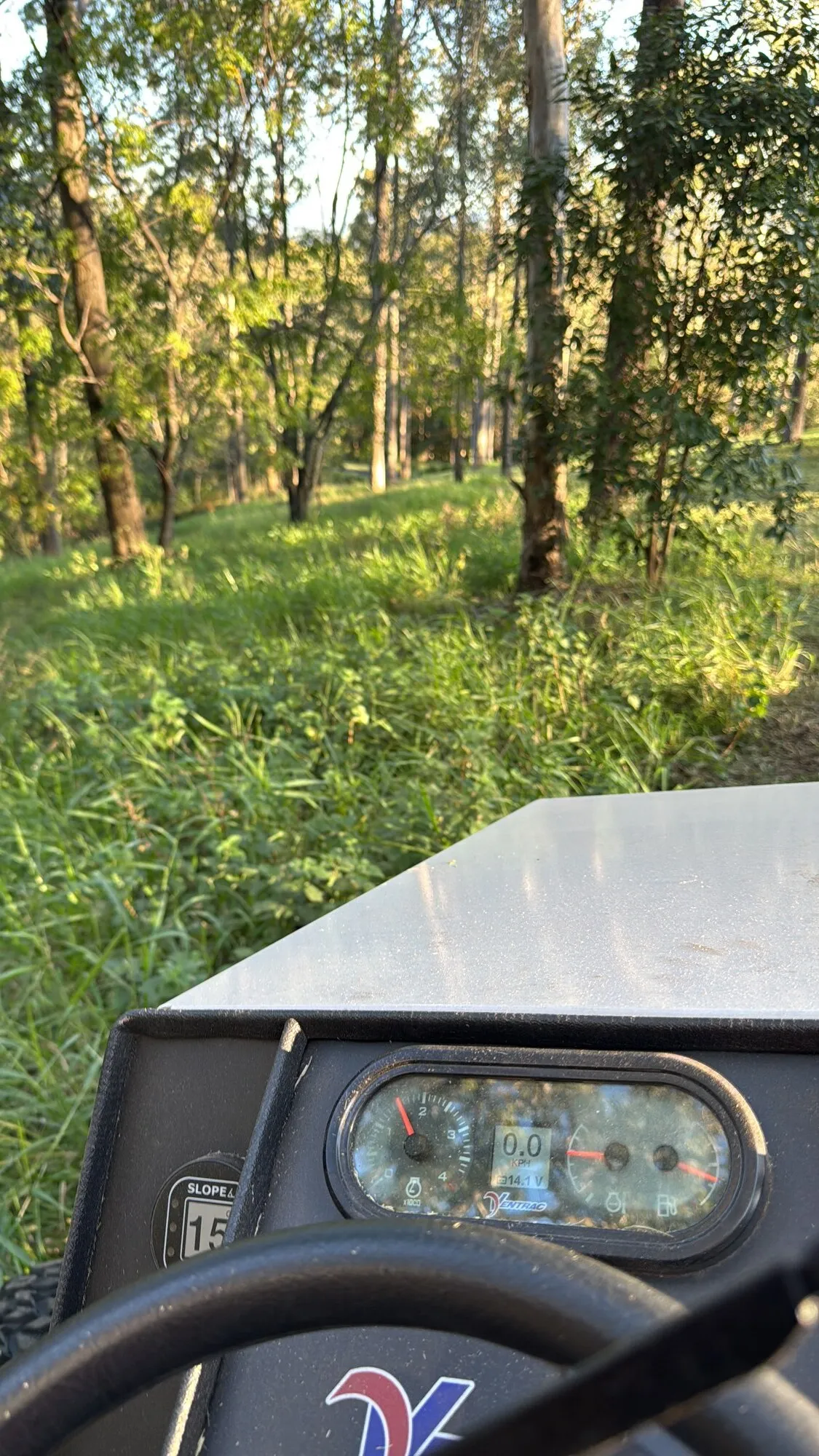 View from the Ventrac cab with the on-board slope meter while assessing a wooded slope, Pullenvale
